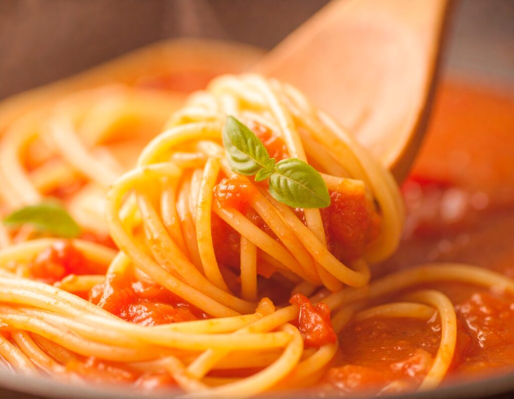 Crockpot spaghetti sauce slow-cooked with herbs and tomatoes in a ceramic pot.